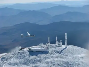 A glider over the snow-covered Mount Washington summit
